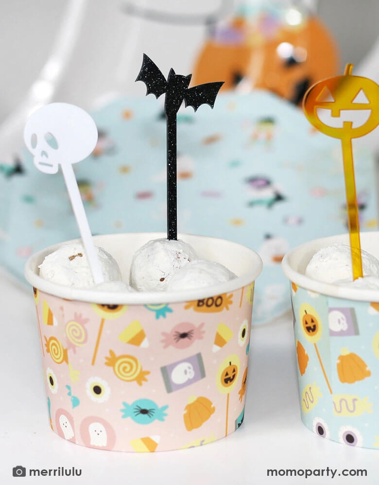 A couple of Halloween snack cups filled with donut walls topped with Momo Party's Halloween Monsters Mash acrylic food picks which feature a skull, a bat, a pumpkin and a ghost. They're perfect for kid's friendly Halloween celebration, a trick or treat party or a Halloween boothday!