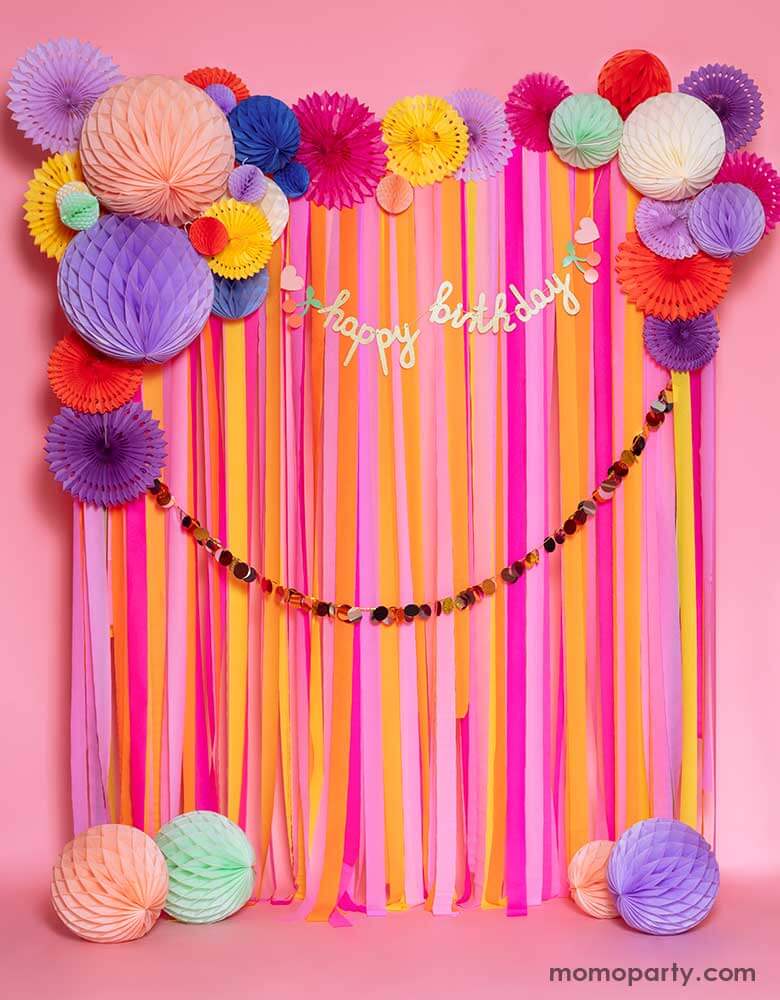 A pink room decorated with colorful paper fans and streamers adorn with happy birthday banner with rainbows and cherries. A cheerful and festive decorations for birthdays of any age.