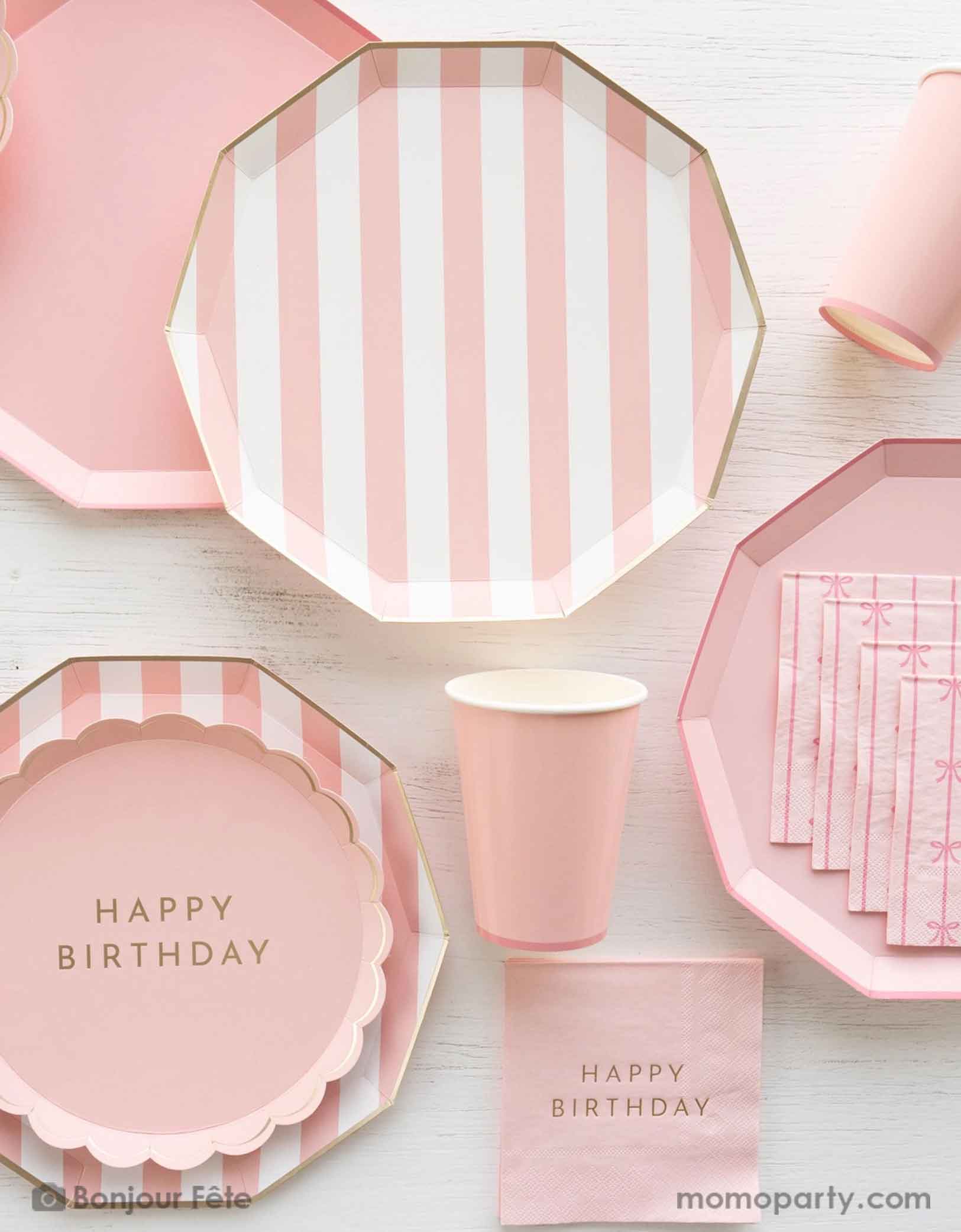 An overhead shot of a party table filled with Momo Party's pastel pink themed party tableware including pastel pink cabana striped dinner plates and pastel pink dinner plates in decagon shape with matching party cups, with the pink scalloped round plate with Happy Birthday on it - a great party collection for girl's birthday celebration.