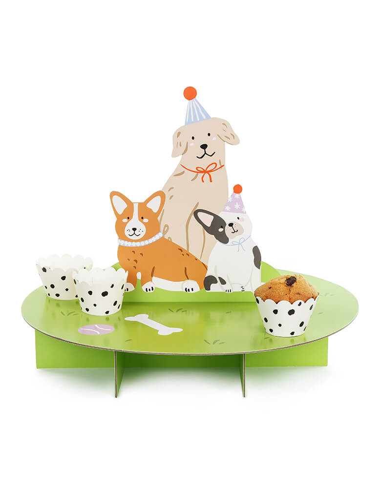 Momo Party's 17.7" x 13.7" Dog Cupcake Stand by Party Deco. This cute and adorable stand is designed with playful puppies and is sure to add some fun to any celebration. With Dalmatian printed cupcake wraps, and green stand like turf, it's the perfect way to display your treats.