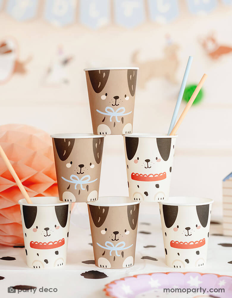 An adorable dog puppy themed birthday party table featuring Momo Party's 7.4 oz Dog Party Cups by Party Deco. These cups come in 2 designs one in cream color and the other in brown with adorable dog design on it are stacked up as a cup tower. With the Dalmatian dot tablecover underneath, pastel honeycomb decorations around the table and a happy birthday banner in the back, this makes a cute scene for kid's dog themed birthday party celebration.