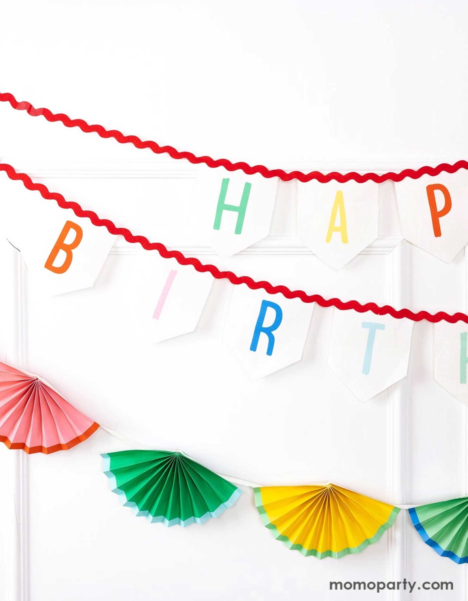 A white wall decorated with Momo Party's 6' Happy Birthday Felt Banner & colorful bunting garland by My Mind's Eye. Celebrate in style with these amazing Happy Birthday decorations! These banners will elevate any party with its vibrant design and premium felt material. Perfect for any birthday celebration, these cheerful decorations will bring joy and excitement to any special occasion. Check out momoparty.com for more birthday party supplies now!