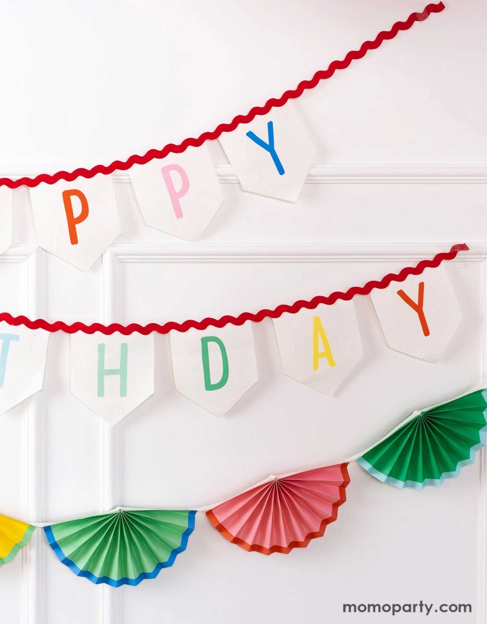 A white wall decorated with Momo Party's 6' Happy Birthday Felt Banner & colorful bunting garland by My Mind's Eye. Celebrate in style with these amazing Happy Birthday decorations! These banners will elevate any party with its vibrant design and premium felt material. Perfect for any birthday celebration, these cheerful decorations will bring joy and excitement to any special occasion. Check out momoparty.com for more birthday party supplies now!