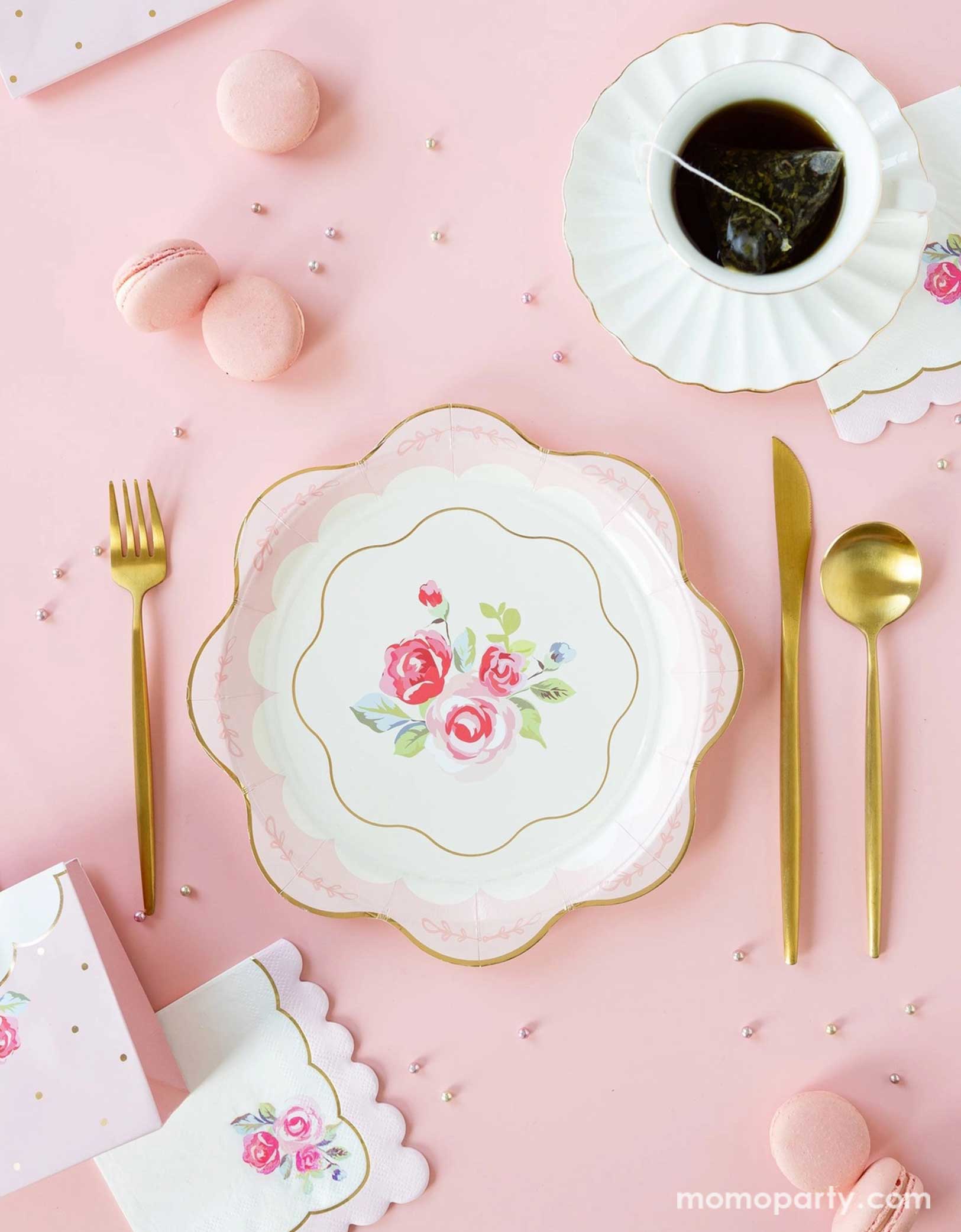 Elevate your tea party with Momo Party's Tea Party themed party supplies by My Mind's Eye. This elegant setup features tea party rose scallop-edged plates, rose corner small napkins, golden utensils. Along with a tea cup set with gold foil edge and pink macarons on a soft pink backdrop. Perfect for bridal showers, baby showers, or whimsical tea parties, these Teat Party supplies add a touch of charm and sophistication to any celebration. Check out momoparty.com for more!