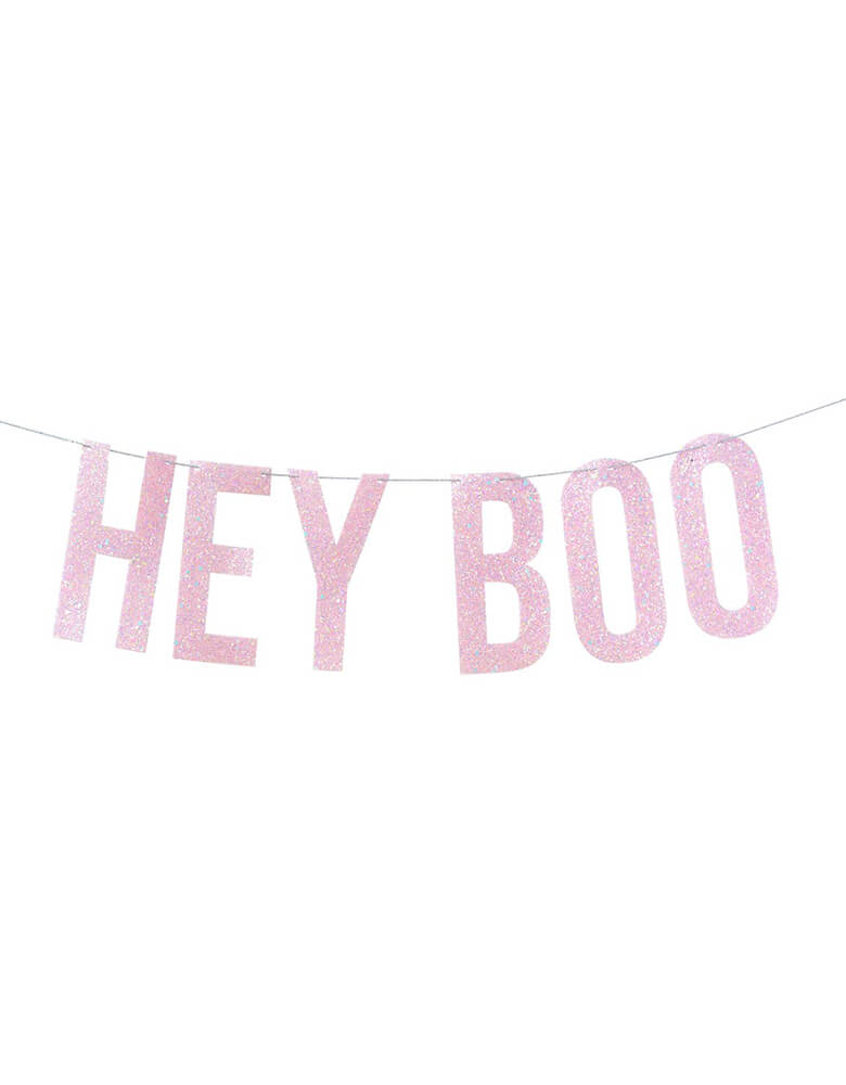 Hey Boo Banner Pink by Studio Pep. This boo-tiful hand-pressed artisan banner is cut from high quality, pastel pink neon-edge vinyl with glitter and includes thick glitter cord. It's perfect for your pink themed Halloween celebration!